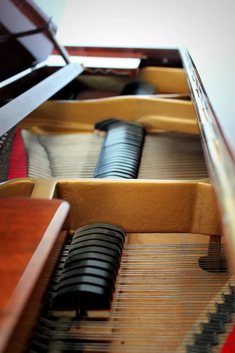 Professional piano movers carefully handling an upright piano in a Perth home